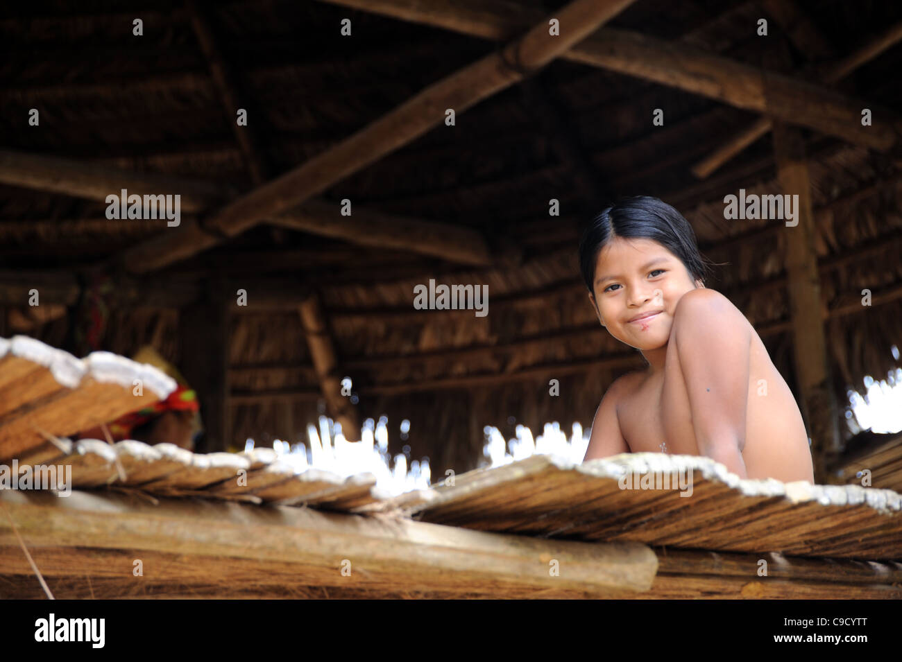 Embera indian girl smiling and wellcoming in her hut, Panama Stock Photo