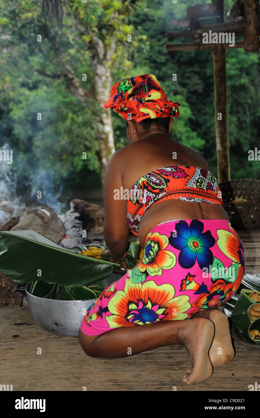 Embera woman cooking on knees at Embera Puru community in Panama. Stock Photo