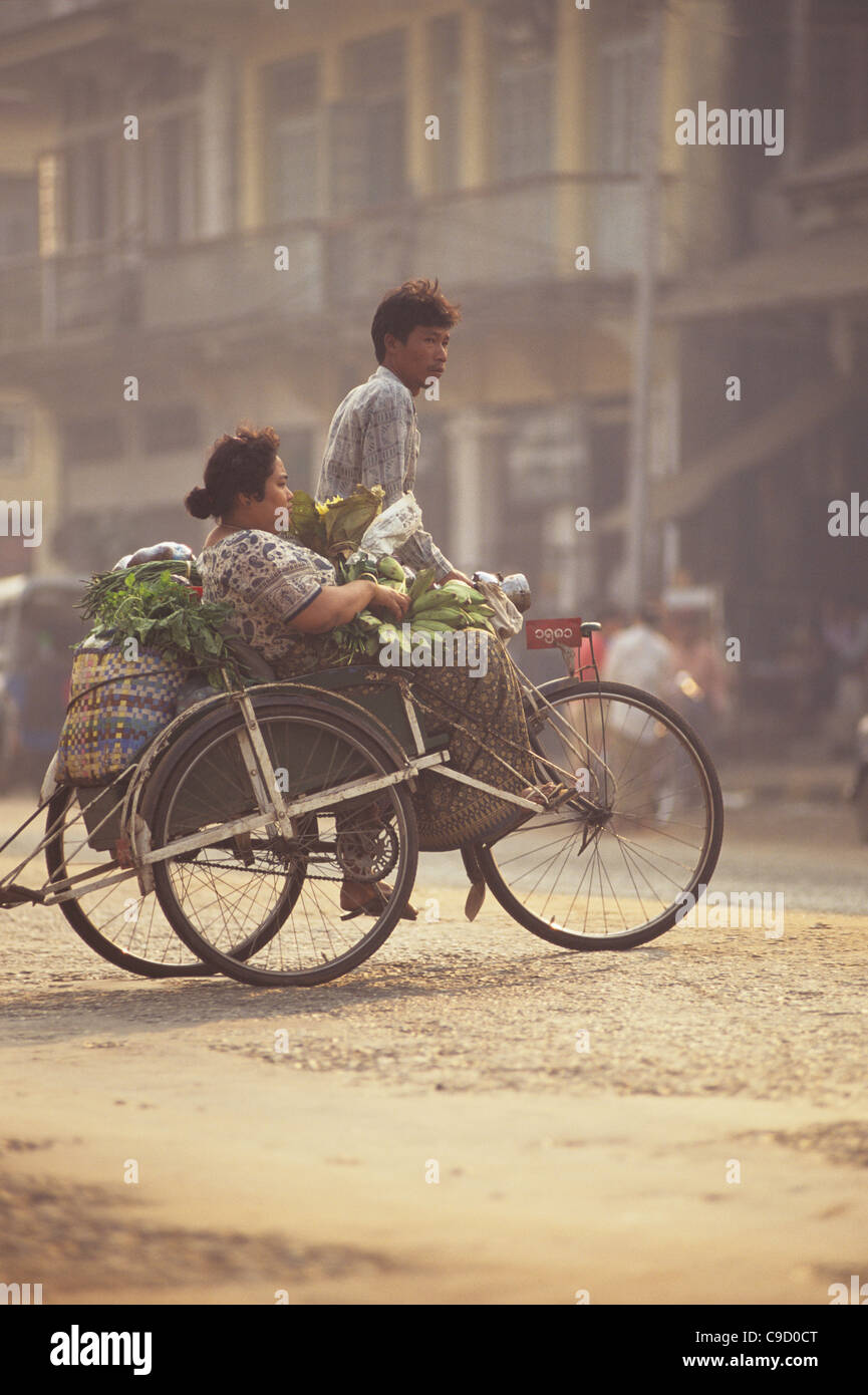 Bago City scene, 3 wheel bicycle taxi, male driver and female passenger ...