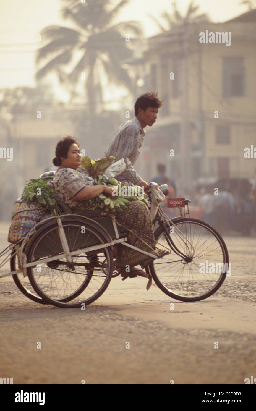 Bago City scene, 3 wheel bicycle taxi, male driver and female passenger ...