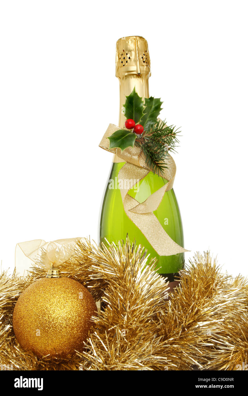 Christmas champagne, a bottle of champagne decorated with holly and a ribbon surrounded by tinsel and a golden bauble Stock Photo