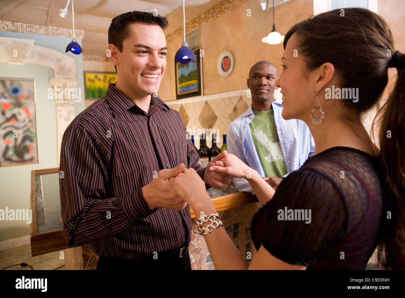 Smiling young couple holding hands Stock Photo - Alamy