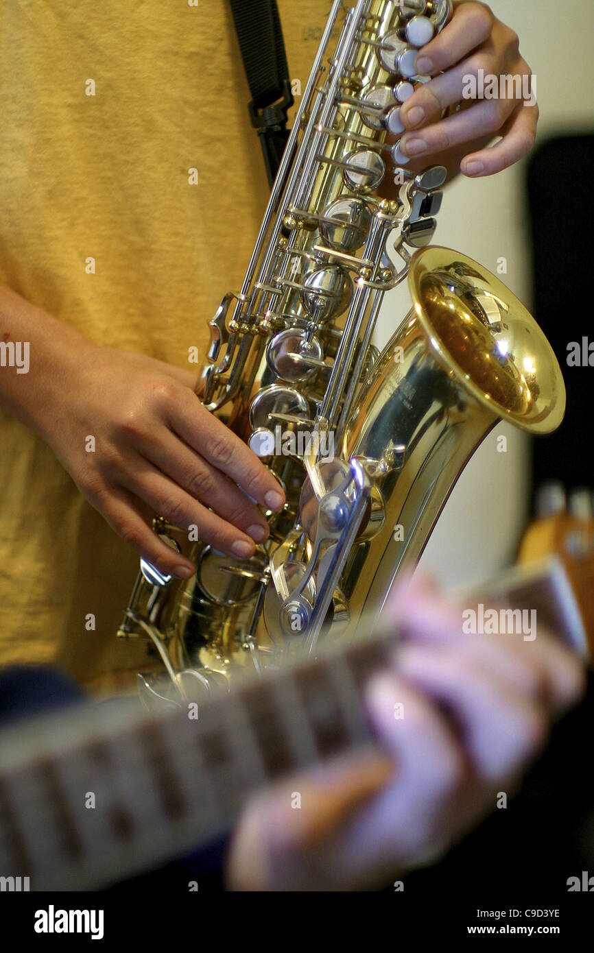 Two people playing a guitar and a saxophone Stock Photo