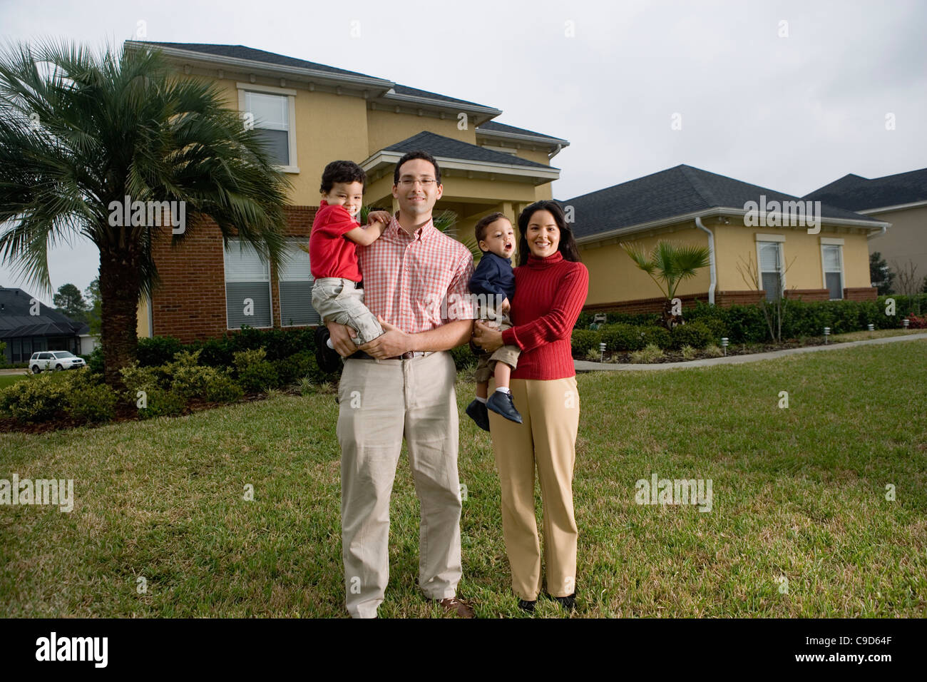 Portrait of family standing outside house Stock Photo Alamy