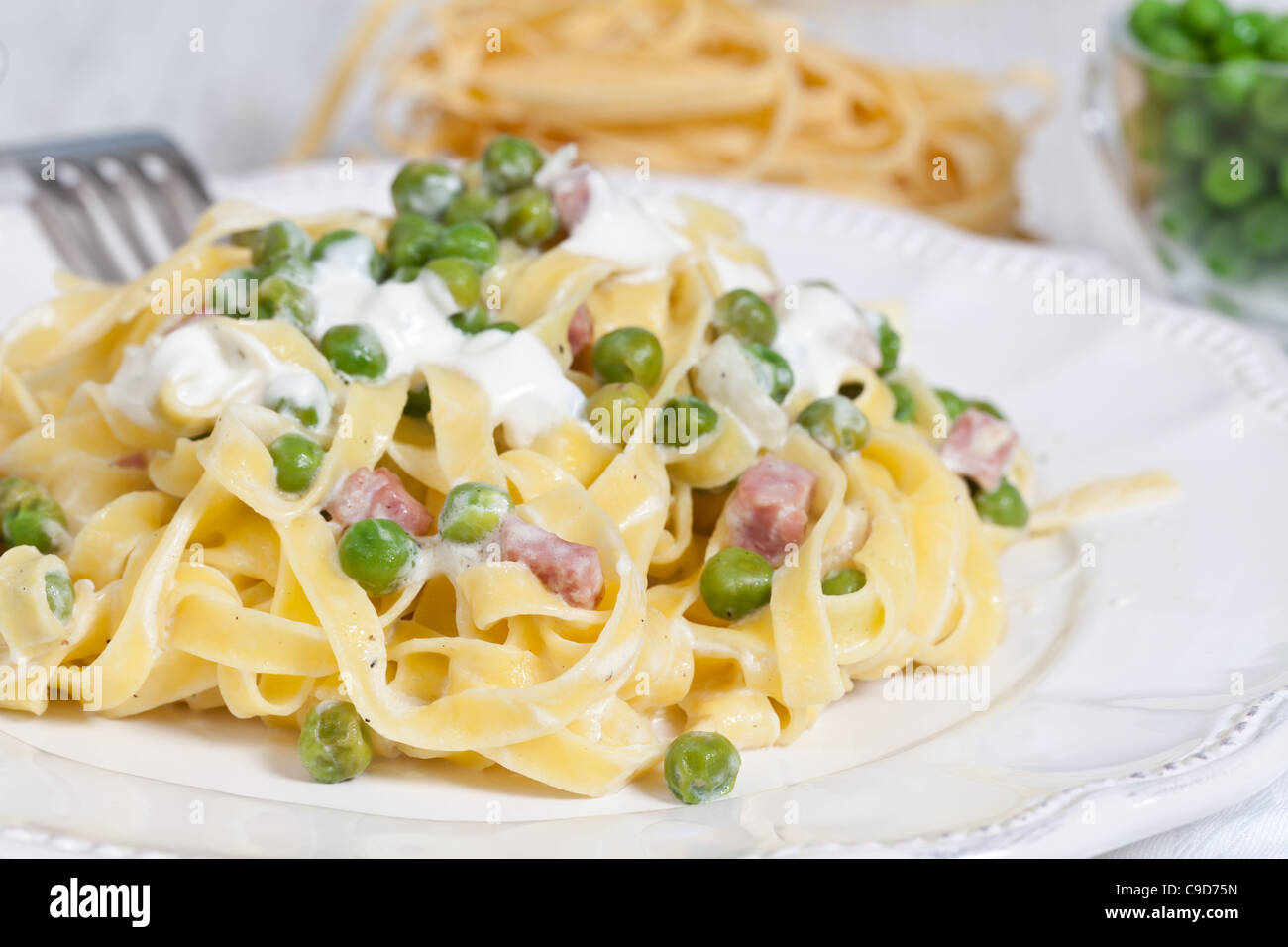 Egg noodles with cream, ham and green peas Stock Photo - Alamy