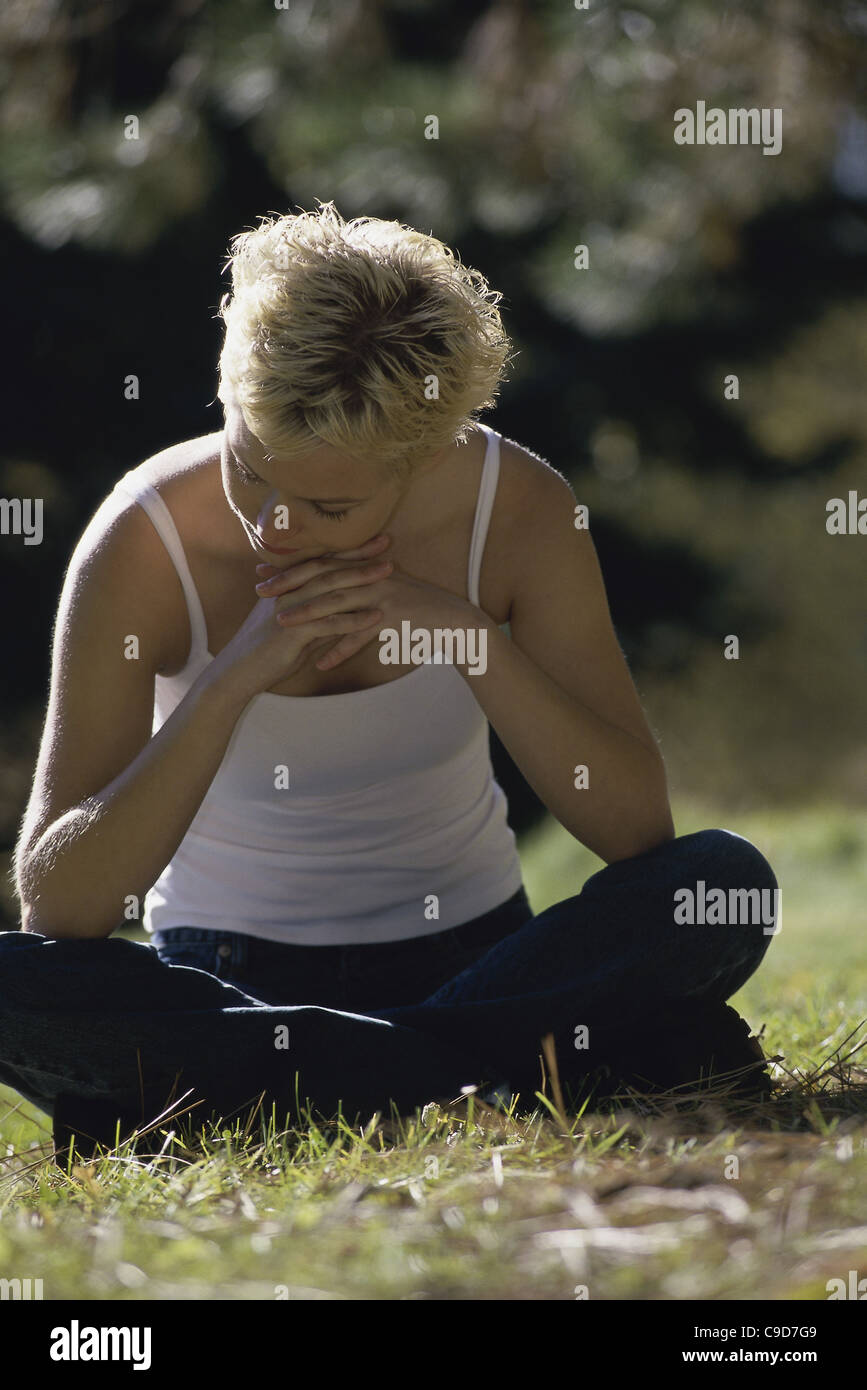 Young woman sitting on a lawn Stock Photo - Alamy