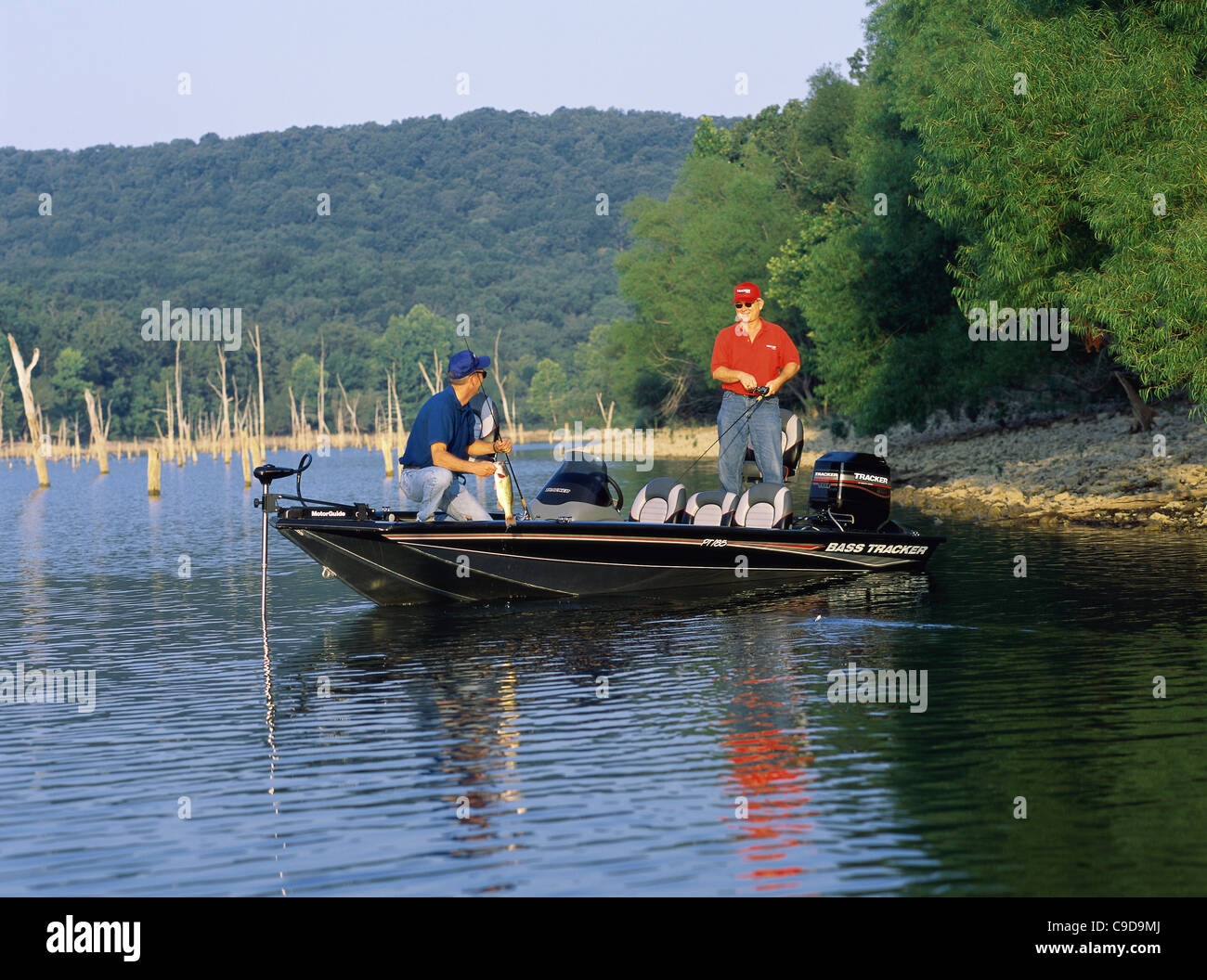 Two people standing in a boat fishing Stock Photo - Alamy