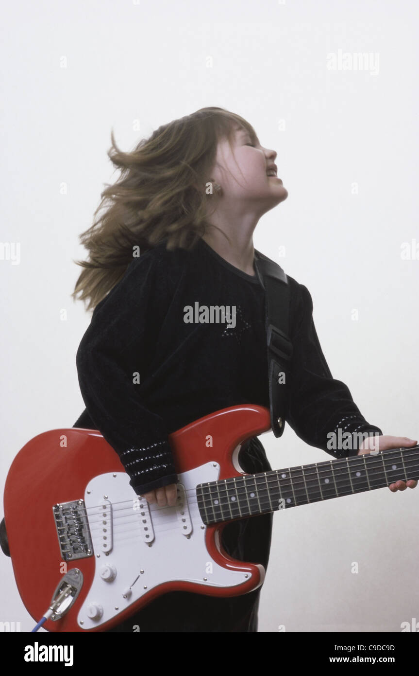 Girl standing holding electric guitar hi-res stock photography and ...