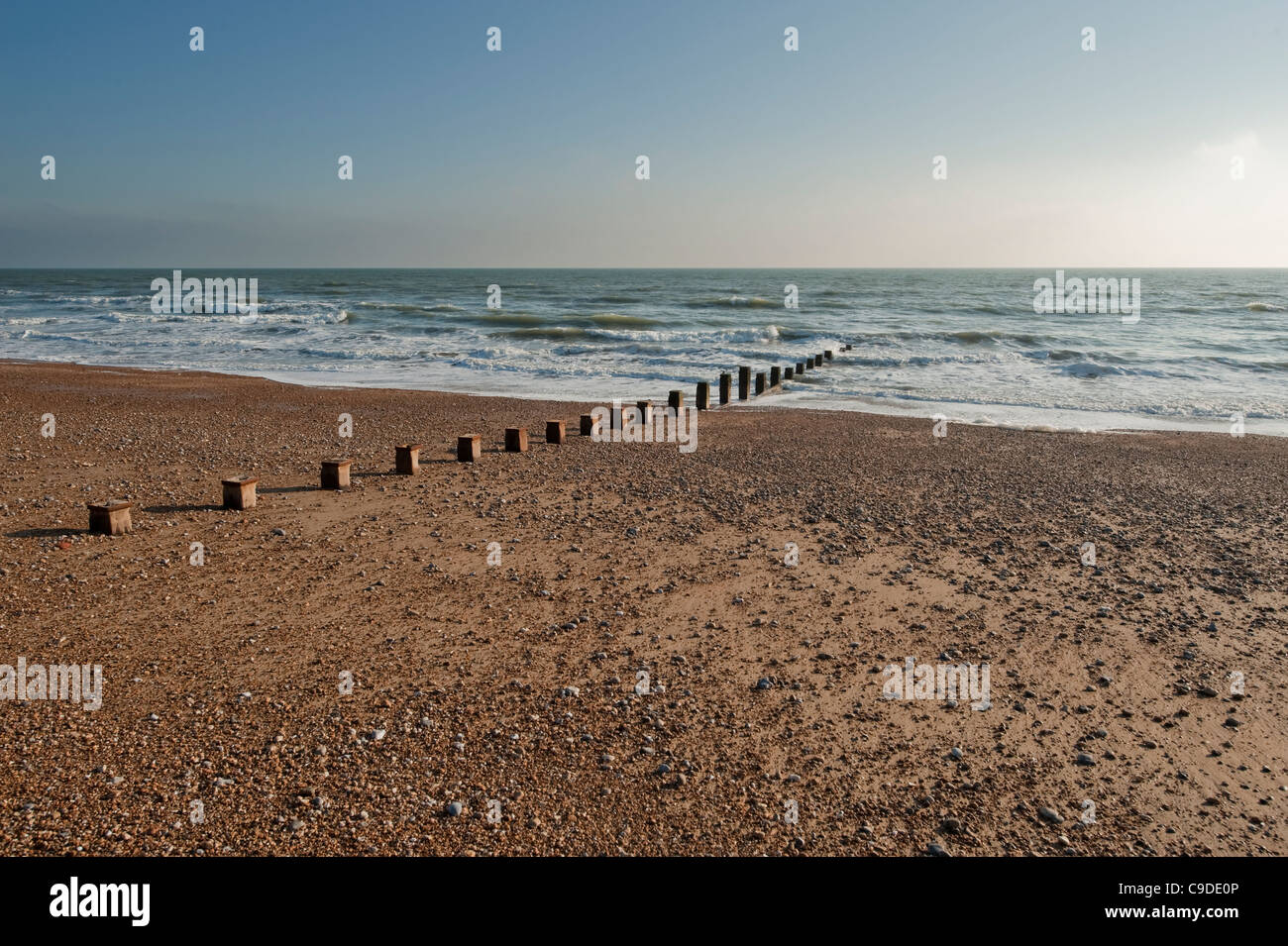 The shingle beach at Bexhill on Sea, East Sussex, in Autumn evening light with wood groin Stock Photo
