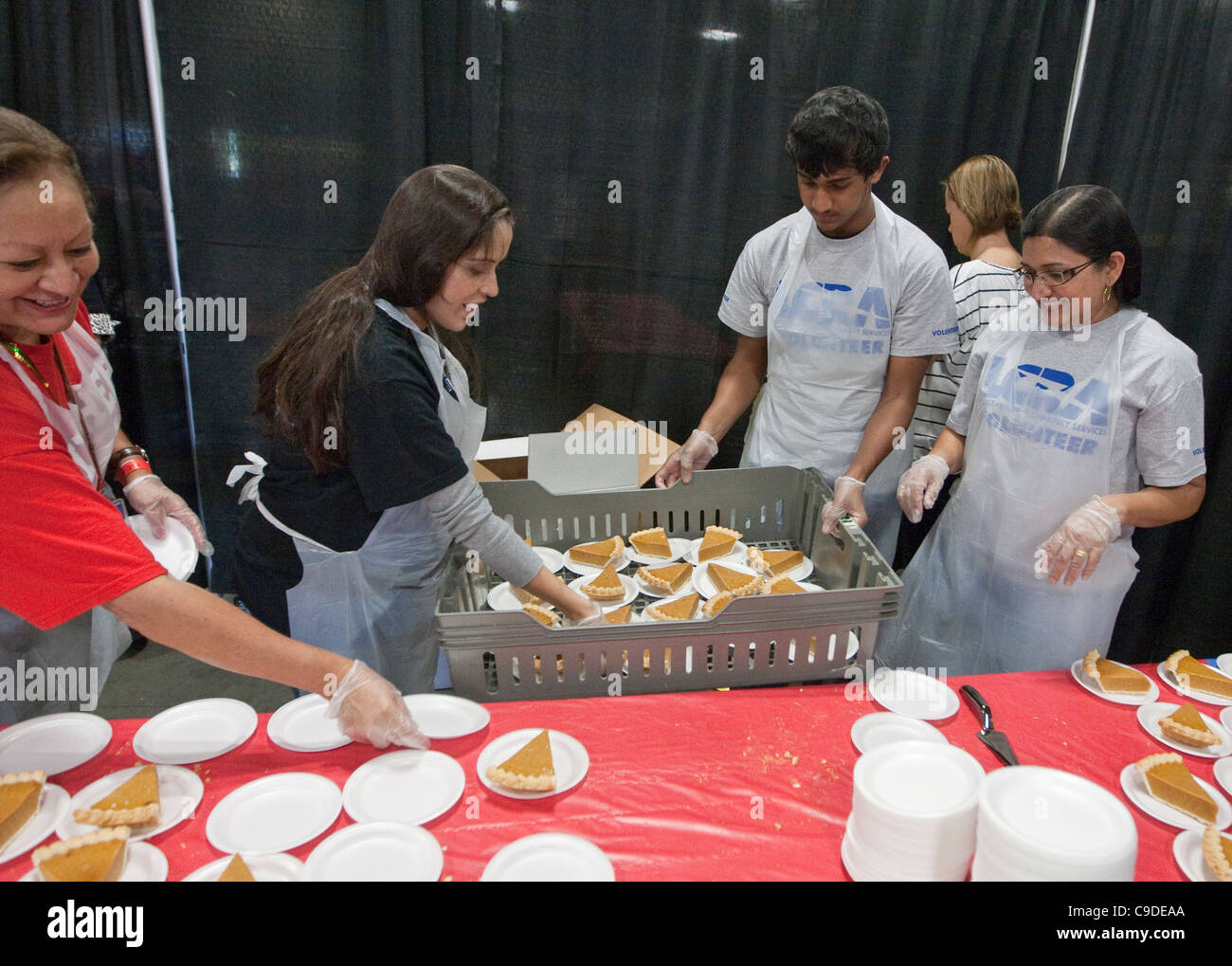Volunteers hand serve and handout food to attendees of free Thanksgiving meal donated by Texas supermarket Stock Photo