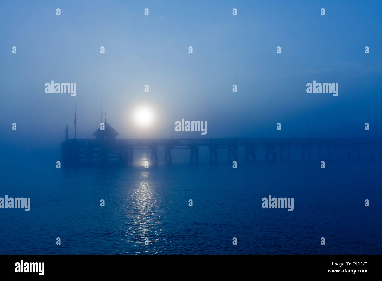 Empty Yarmouth wooden Pier Isle of Wight at sunrise in the fog and mist Stock Photo
