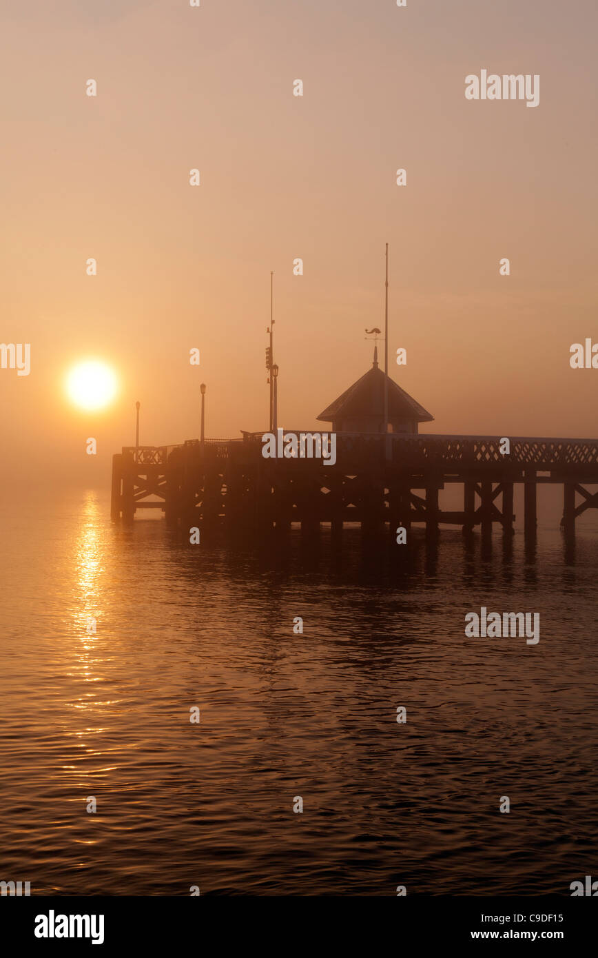 Empty Yarmouth wooden Pier Isle of Wight at sunrset in the fog and mist Stock Photo