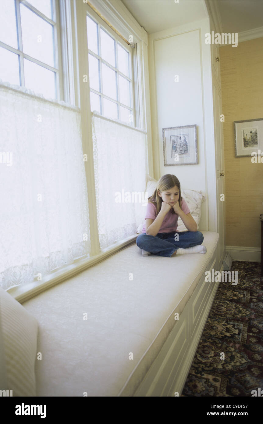 Teenage girl sitting on a sofa Stock Photo - Alamy