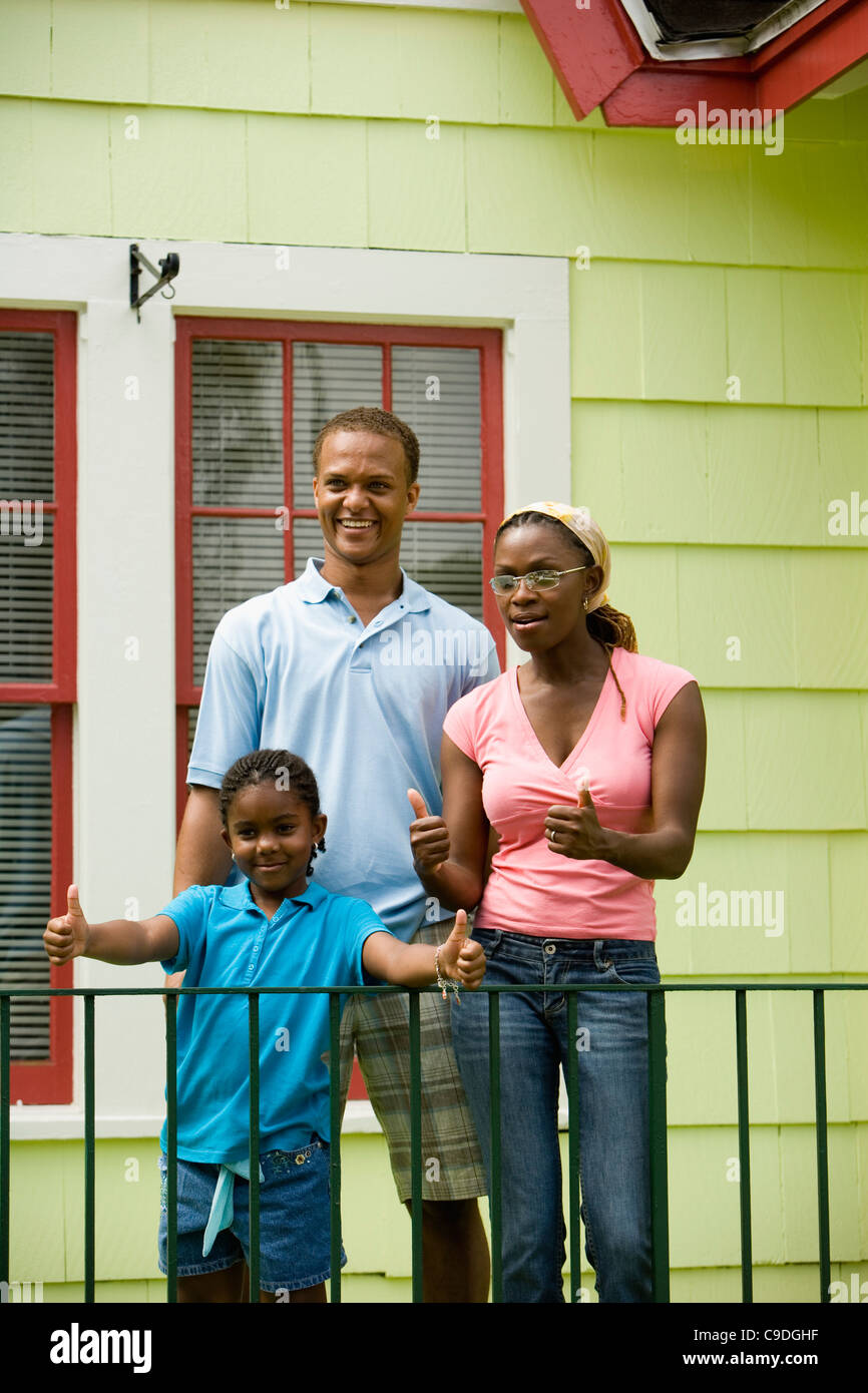 Cheerful family standing by a railing outside a house Stock Photo - Alamy