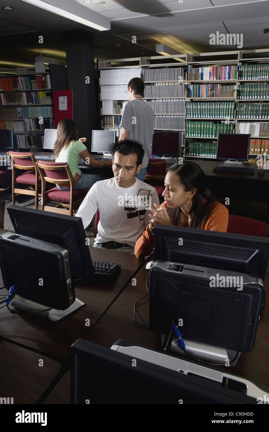 College students using computers in the library Stock Photo Alamy