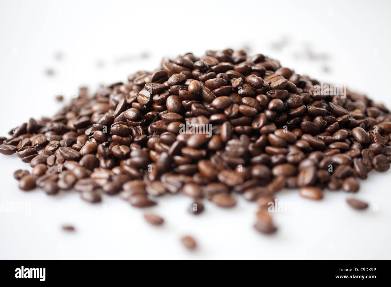 a heap of coffee beans on white background Stock Photo - Alamy