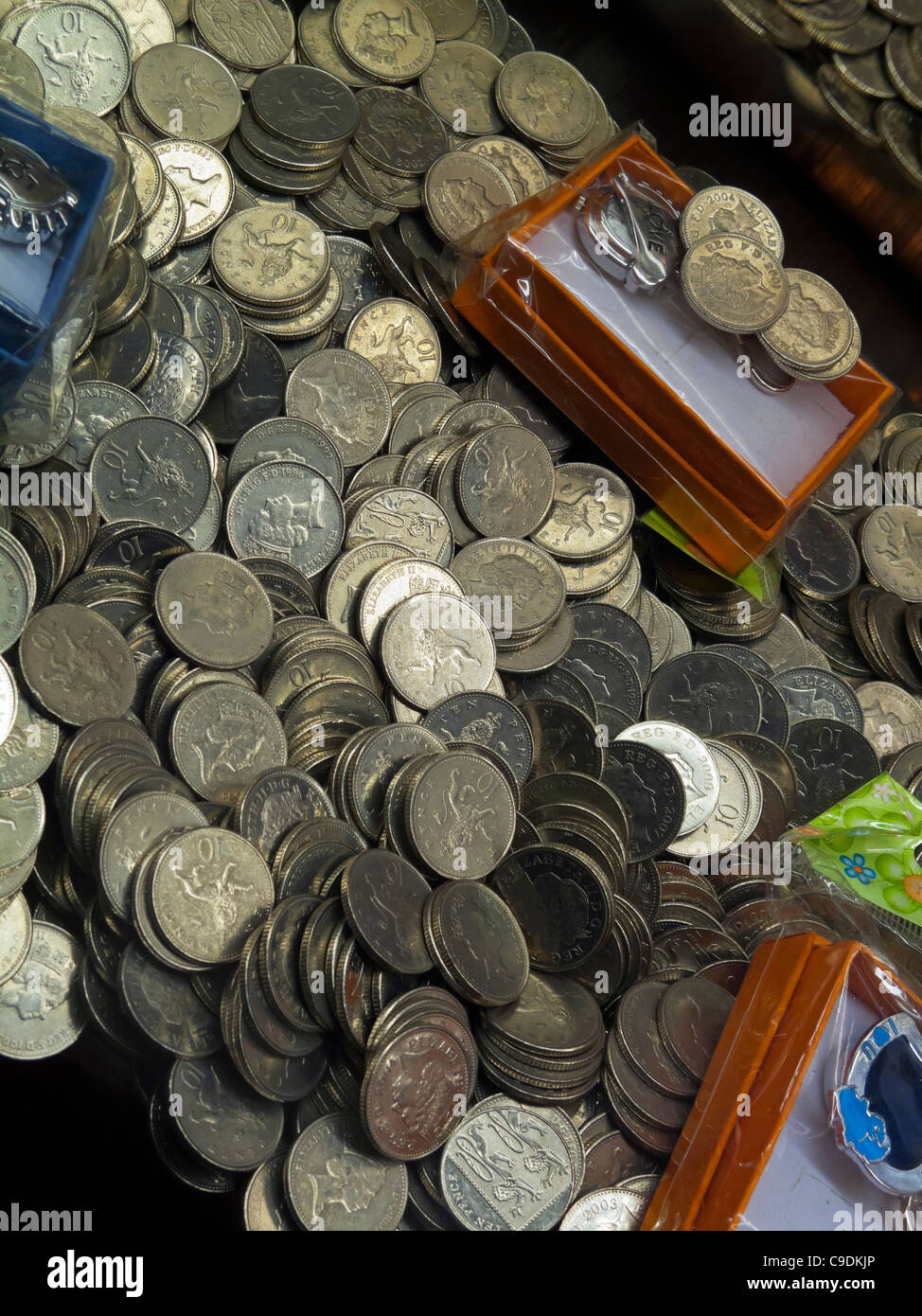 British ten pence coins in an amusement arcade coin waterfall game where coins fall as prizes when new ones are inserted above Stock Photo