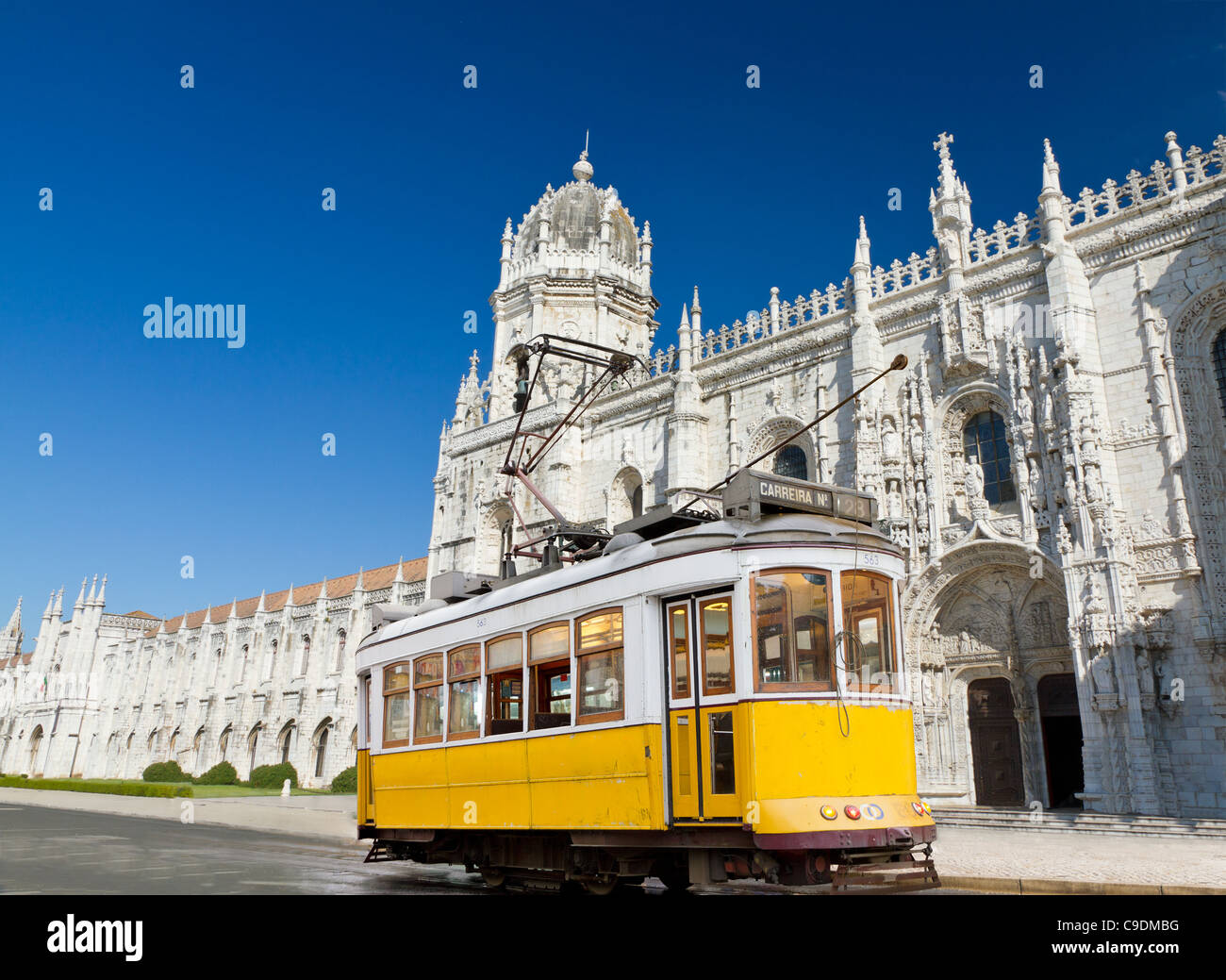 historic classic yellow tram of Lisbon built partially of wood in front of famous Jeronimos monastery, Portugal Stock Photo