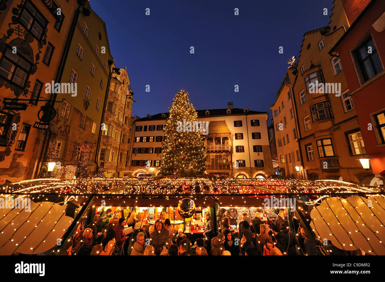 Innsbruck Christmas Market in the center of the old town with The Golden Roof in the background behind the tree. Stock Photo