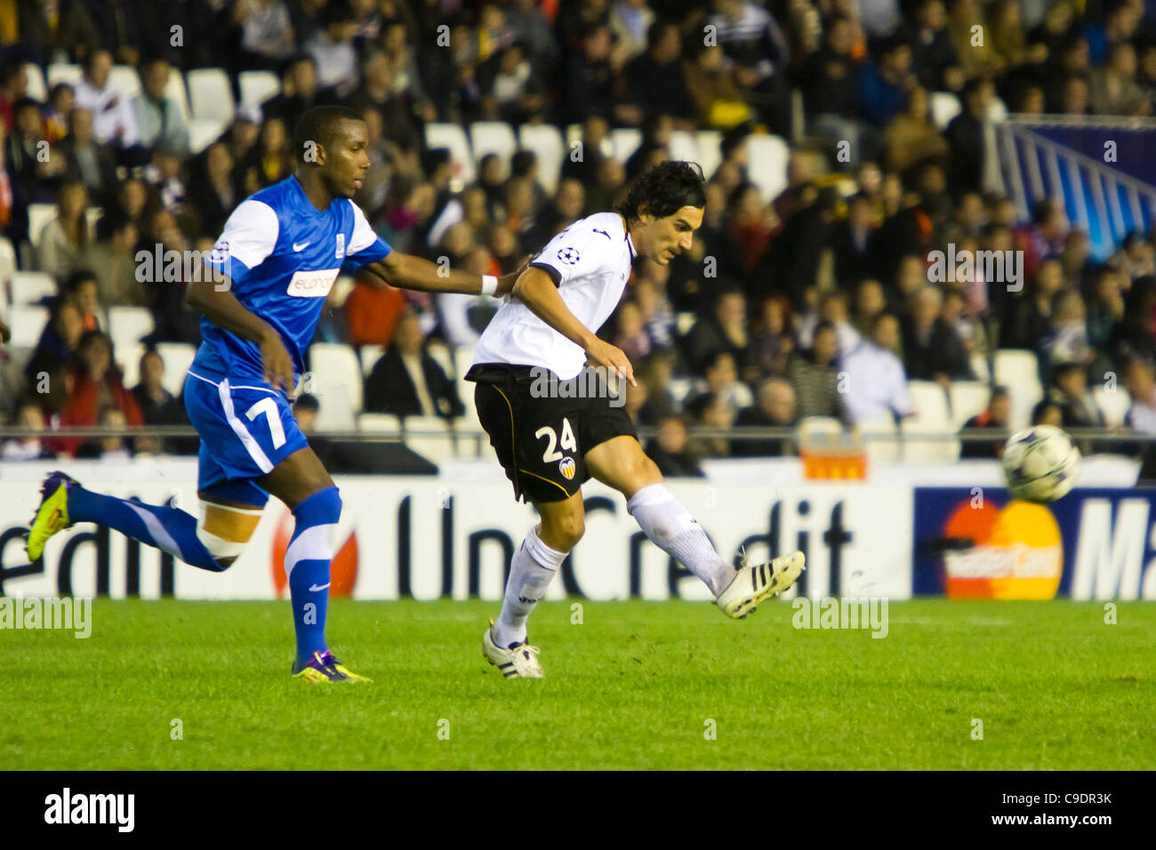 23/11/2011. Valencia, Spain  Football match between Valencia Club de Futbol and KRC Genk, Matchday 5, E Group, Champions League -------------------------------------  Tino Costa midfield player from VAlencia CF as he passes the ball with some oposition from Khaleem Hyland from KRC Genk Stock Photo