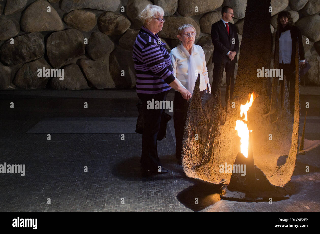 Anna Suchecka (L) and Hedva Gil (R) light the Eternal Flame in the Yad Vashem Hall of Remembrance in a memorial ceremony honoring the victims of the Holocaust. Jerusalem, Israel. 28th November 2011. Stock Photo