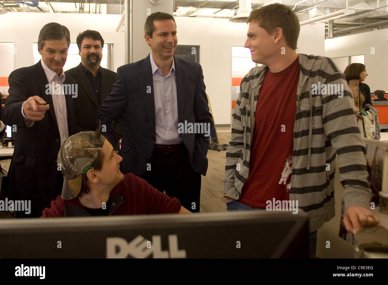 London Ontario, Canada - November 28, 2011. Dalton McGuinty, Premier of Ontario, centre talks with Casey Baldwin, right and Andrejs Verlis, seated, two designers with the computer game company Digital Extremes. McGuinty was on tour of the London company along with Chris Bentley MPP of London West, r Stock Photo
