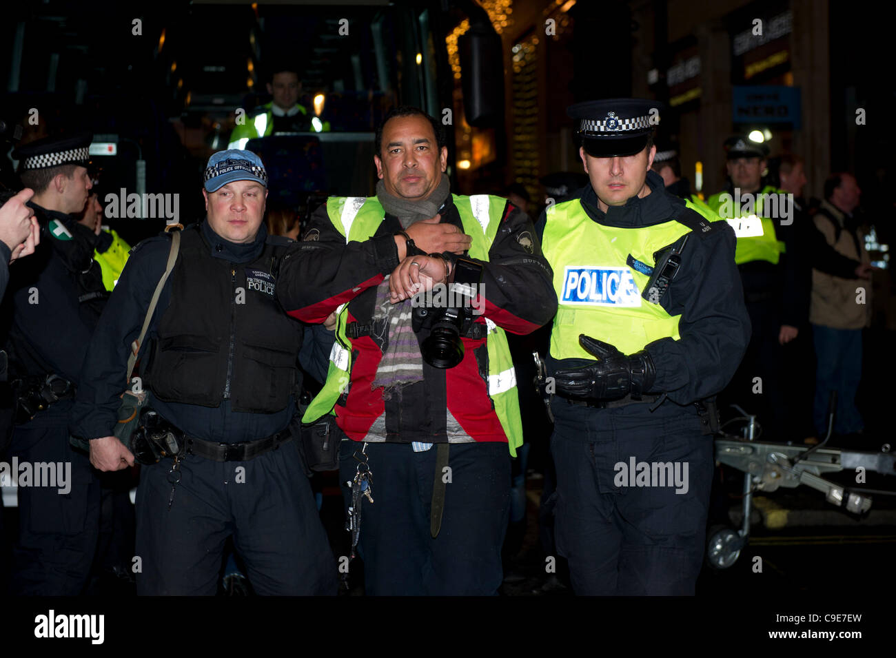 30th Nov 2011, Haymarket, London. A photographer is led away in handcuffs by Police and escorted to a waiting coach after the attempted occupation of Panton House off Haymarket, London. According to some reports, the protesters were thought to be part of Occupy London Stock Exchange (OLSX). Stock Photo
