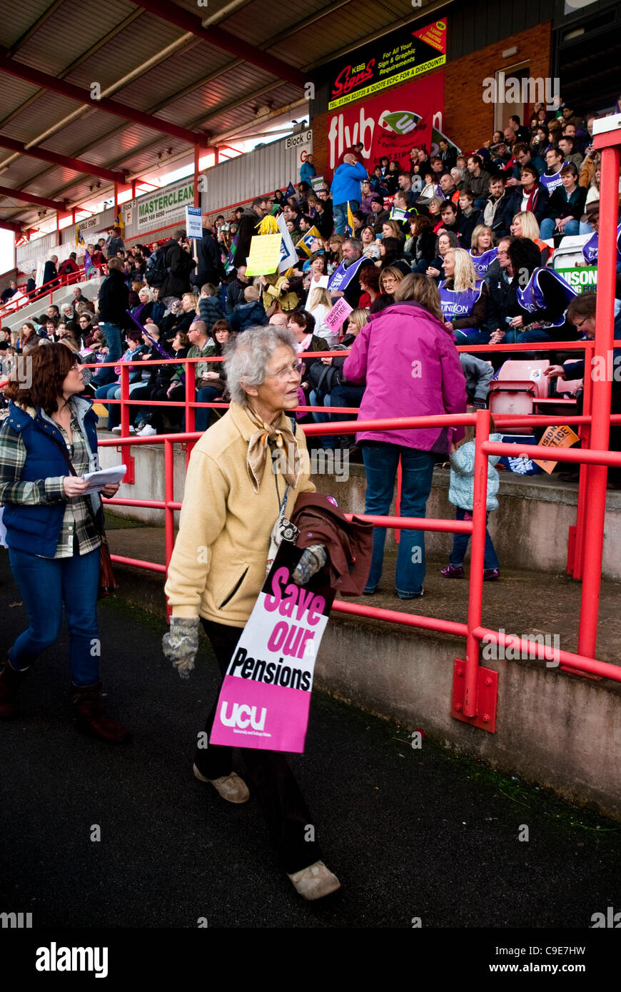 Exeter, UK. 30th Nov, 2011.  Woman with a UCU placards saying 'Save our pensions' hurries to her seat at St James park for the Exeter N30 rally as part of the national protest against proposed changes to public sector pensions. Stock Photo
