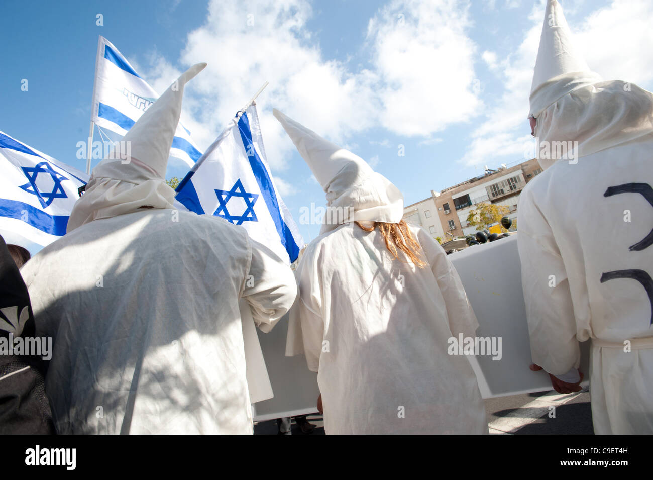 TEL AVIV - DECEMBER 9: Israeli activists dress as KKK members to satirize right-wing Israeli policies and politicians during in the annual human rights march in Tel Aviv. Stock Photo