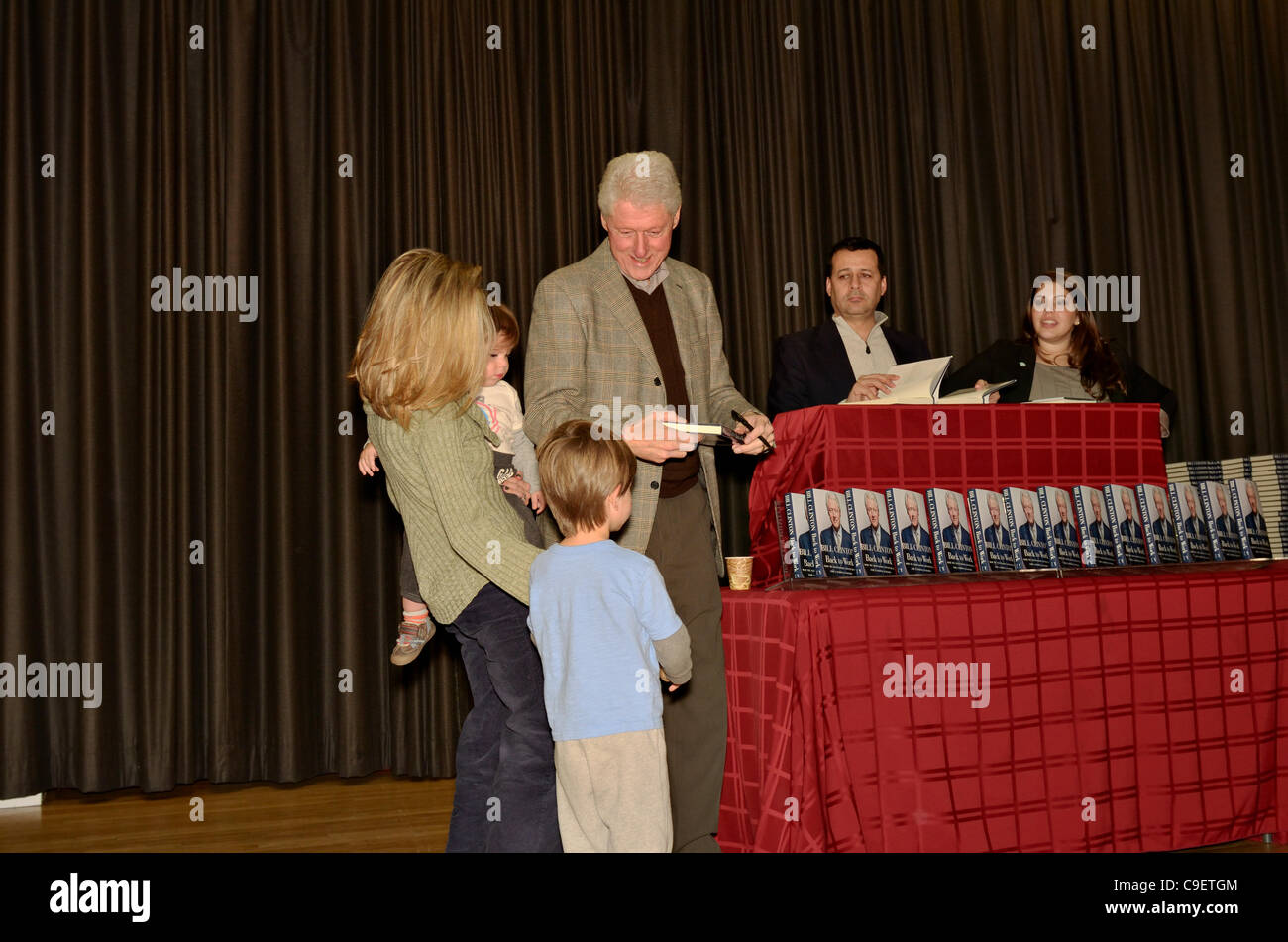 President Bill Clinton chats with mother and young children and signs copies of his new book