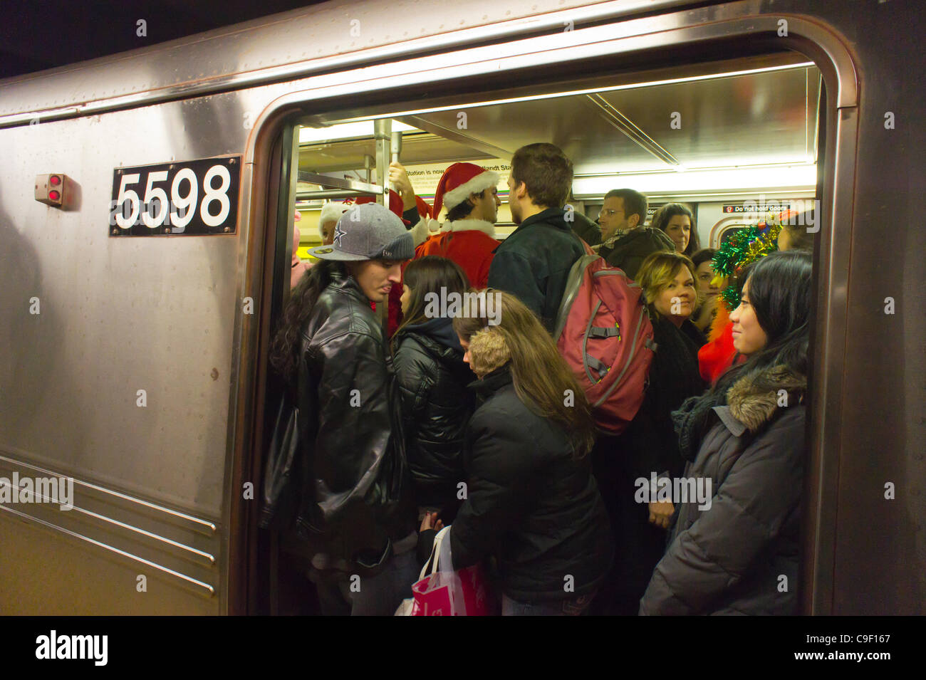 Christmas revelers participating in the annual Santacon travel on the subway in New York on Saturday, December 10, 2011. Santacon, primarily a pub crawl in Santa and other Christmas related costumes, attracts hundreds of masqueraders going from bar to bar. The drinkers were encouraged to imbibe at e Stock Photo