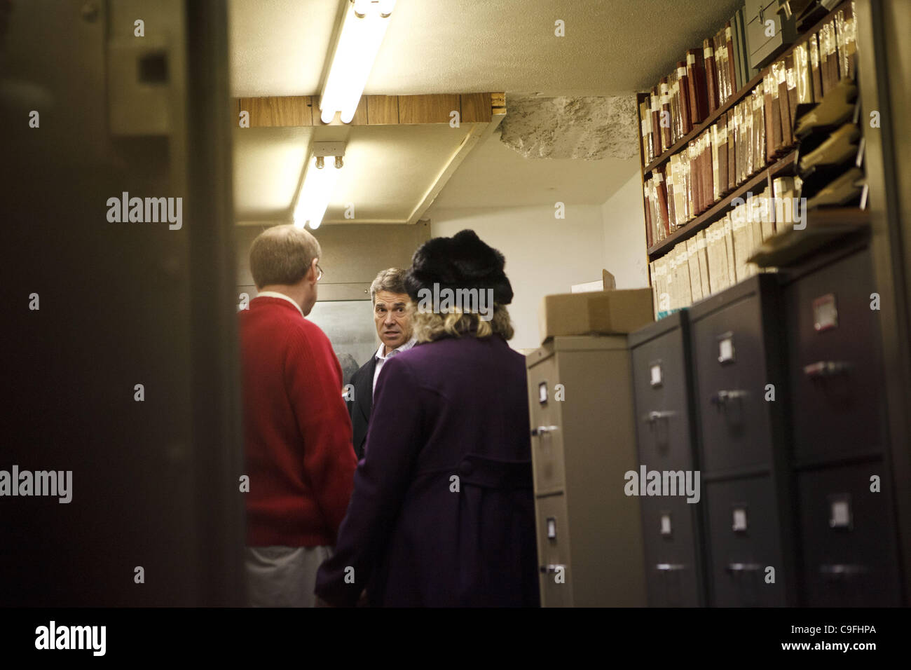 Dec. 14, 2011 - Harlan, Iowa, U.S. - Republican presidential candidate Texas Gov. Rick Perry talks with small business owner Randy Ouren and Dawn Cundiff of the Shelby County Chamber of Commerce in an old bank vault used to maintain property titles and records as he campaigns during a Main Street To Stock Photo