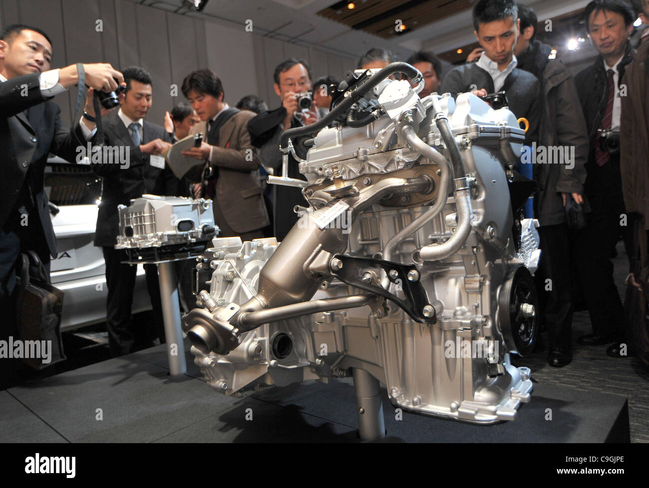 December 26, 2011, Tokyo, Japan - Reporters take a closer look at the engine of Toyota's Aqua compact hybrid model during a launch at TokyoMidtown Hall on Monday, December 26, 2011. The Aqua, a smaller version of Prius C, is a compact hatchback with the companys Hybrid Synergy Drive system, measurin Stock Photo