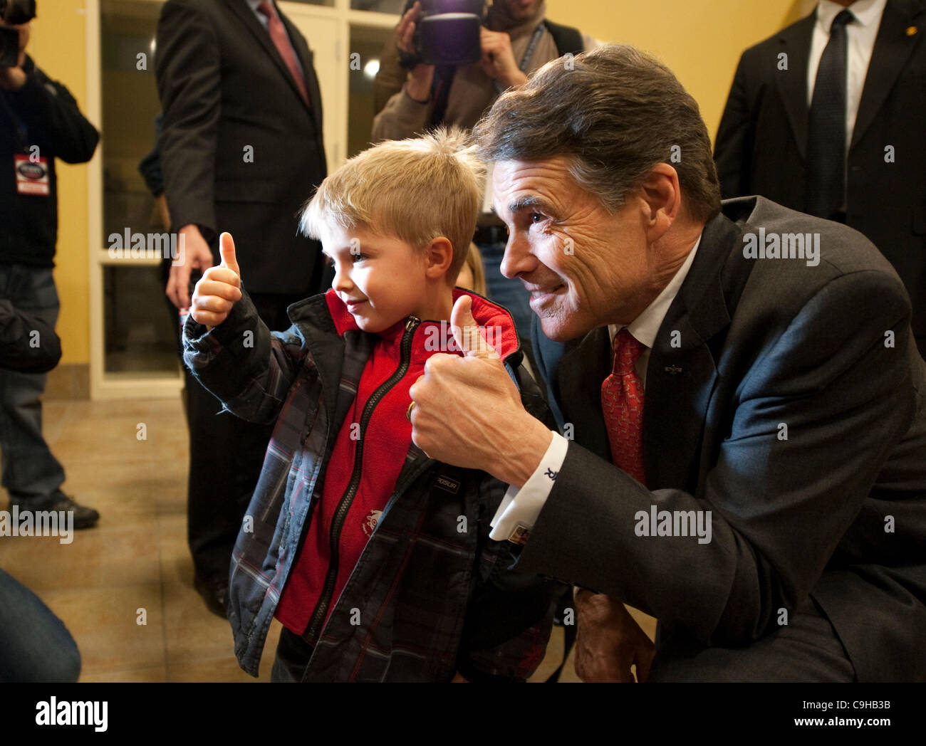 Republican presidential nominee candidate Rick Perry poses with young boy at an Iowa caucus prior to the voting in January 2012 Stock Photo
