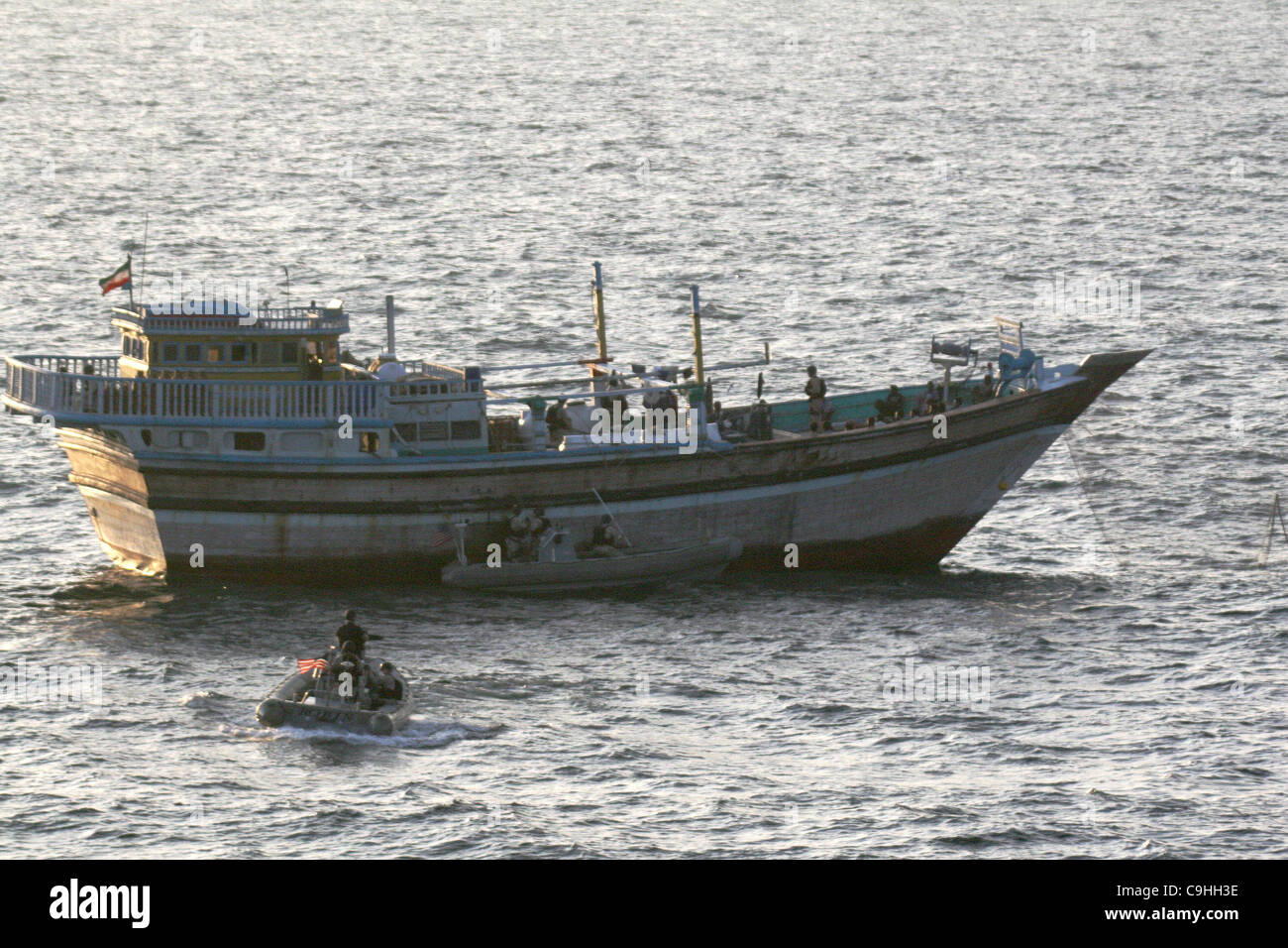 A Sailor aboard a safety boat observes a visit, board, search and seizure team, assigned to guided-missile USS Kidd alongside an Iranian fishing dhow Al Molai after responding to a distress call from the crew who was held captive by Somali pirates January 5, 2012 in the Arabian Sea. The Kidd's visit Stock Photo