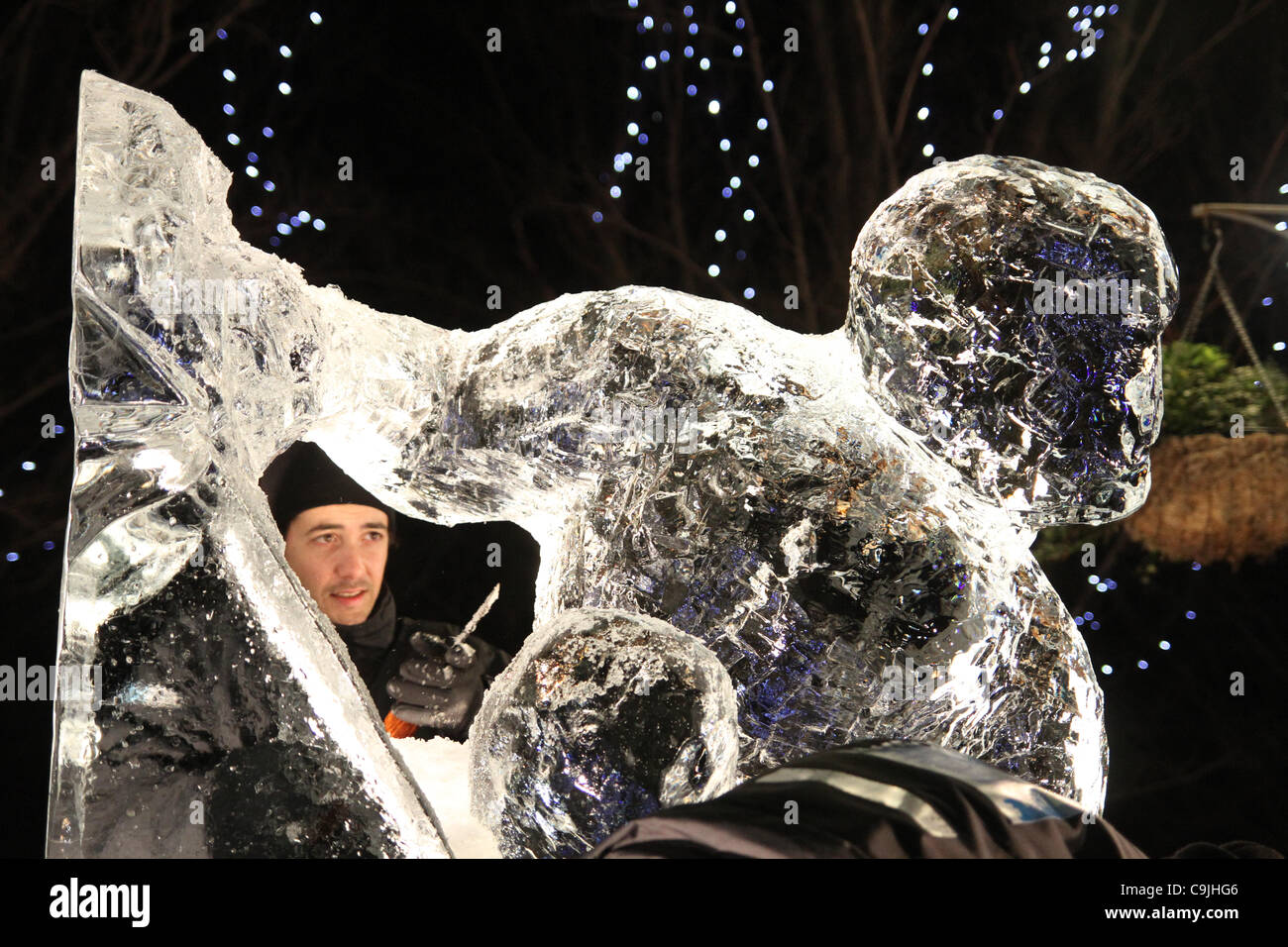 The Portuguese team composed of Pedro Mira & Niall Magee chisel on their  ice sculpture at the  4th annual London Ice Sculpting Festival at Canary Wharf Stock Photo