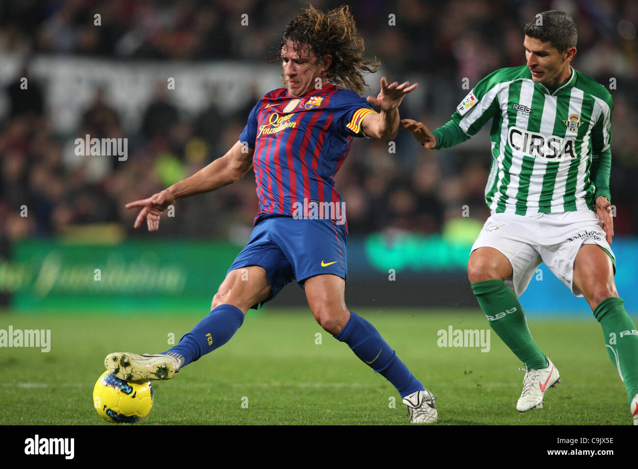 15.01.2012. Barcelona, Spain.  Barcelona's Carles Puyol and Betis' Salva during the match- Barcelona FC versus Real Betis at  Camp Nou Stadiun, Barcelona, Spain. Stock Photo