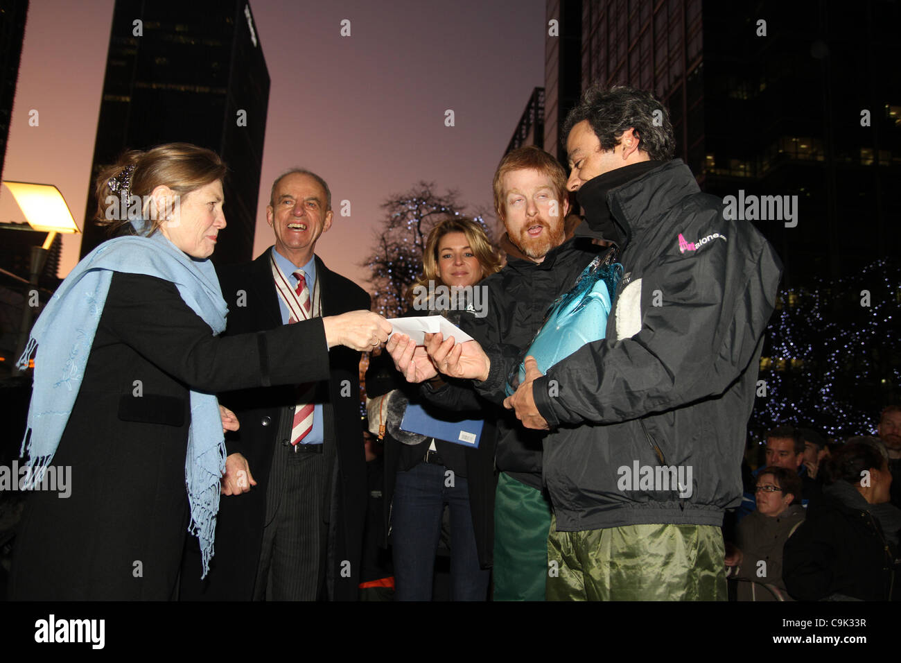 Event organiser Carol Cordrey presents Niall Magee and Pedro Mira of  the Portugal team with a cash award at the 4th annual London Ice Sculpting Festival at Canary Wharf. Credit David Mbiyu/Alamy Live News Stock Photo