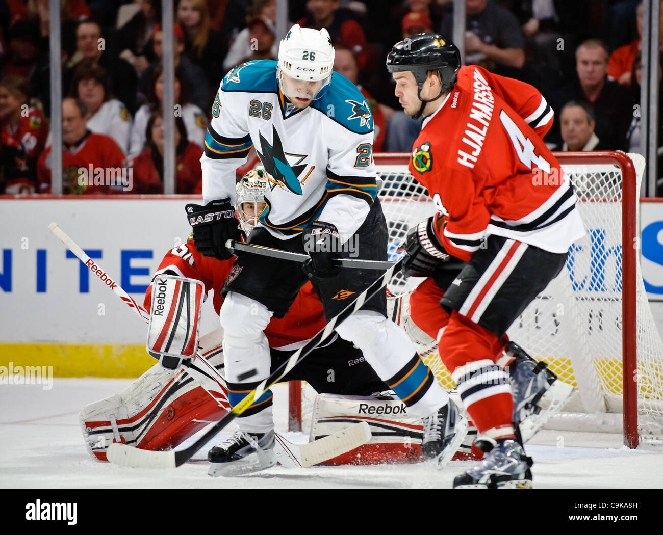 Jan. 15, 2012 - Chicago, Illinois, U.S - San Jose center Michal Handzus (26) and Chicago defenseman Niklas Hjalmarsson (4) fight for position in front of goalie Corey Crawford (50) during the NHL game between the Chicago Blackhawks and the San Jose Sharks at the United Center in Chicago, IL. The Bla Stock Photo