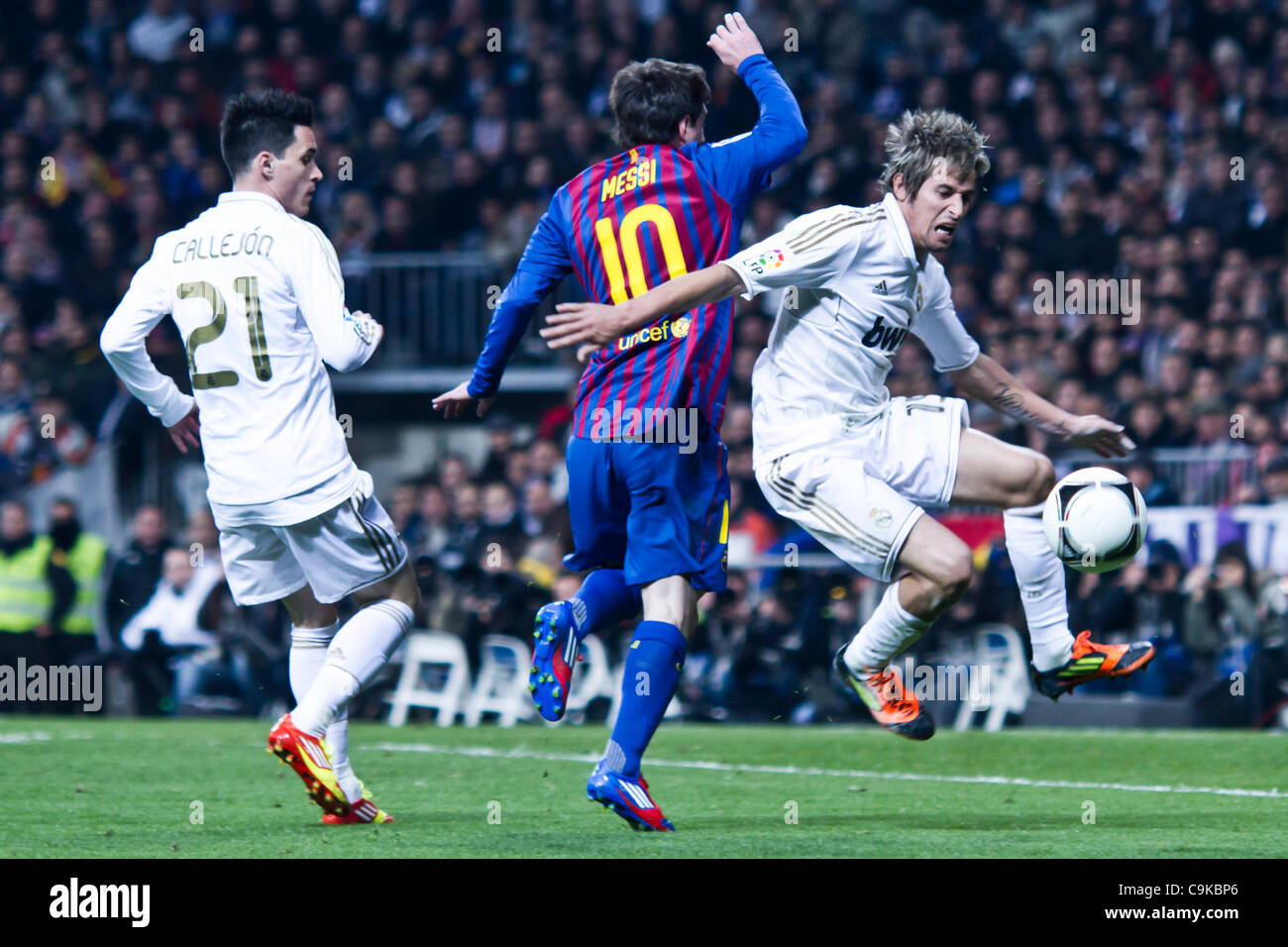 18/01/2011 - MADRID, Spain // COPA DEL REY FOOTBALL - Real Madrid vs. Barcelona - 1/4 finals - Santiago Bernabeu ------------- Fabio Coentrao from Real Madrid takes the ball away from Messi from FC Barcelona Stock Photo