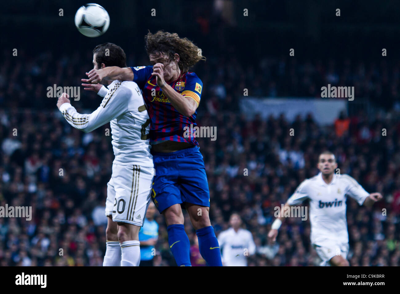18/01/2011 - MADRID, Spain // COPA DEL REY FOOTBALL - Real Madrid vs. Barcelona - 1/4 finals - Santiago Bernabeu ---------- Puyol and Higuain duel for a ball Stock Photo