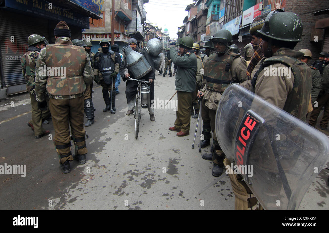 A kashmiri muslim crosses road  as indian police petroling before a protest in Srinagar,the summer capital of indian kashmir on  Jan21, 2012. The protesters were marching towards the Gaw Kadal Bridge here when the police used batons to disperse them. The protests were part of the separatists program Stock Photo
