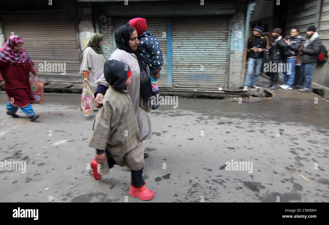 A kashmiri muslim women run for cover with her childerns   during a protest in Srinagar,the summer capital of indian kashmir on  Jan21, 2012. The protesters were marching towards the Gaw Kadal Bridge here when the police used batons to disperse them. The protests were part of the separatists program Stock Photo