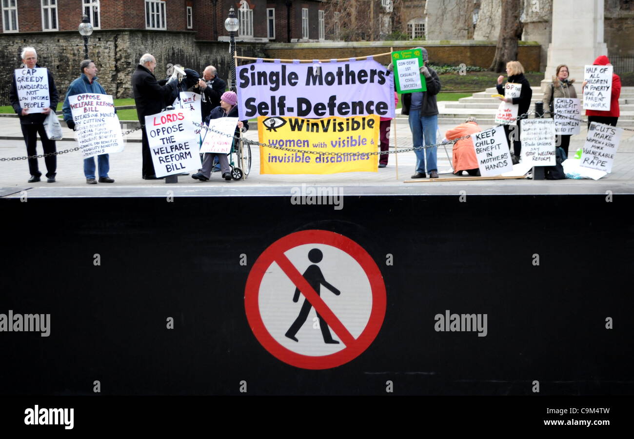 London, UK. 23/01/12. Members of 'Justice for Vulnerable Debtors','Legal Action for Women', 'Single Mothers' Self Defence', 'WinVisible', and 'UKUncut' take part in a protest outside Parliament against the Welfare Reform Bill. (Picture taken from behind security barrier) Stock Photo