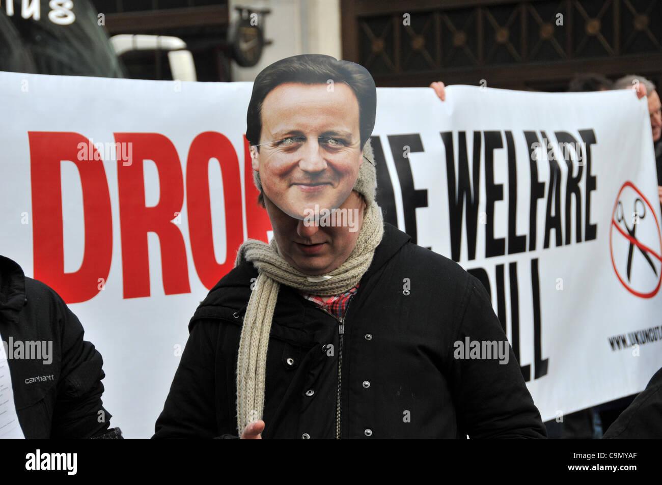 Protesters against the Welfare Reform Bill wearing a David Cameron mask and UKUncut block Oxford Circus Saturday 28/1/12.  Wheelchair users are chained together across the road outside Niketown. Stock Photo