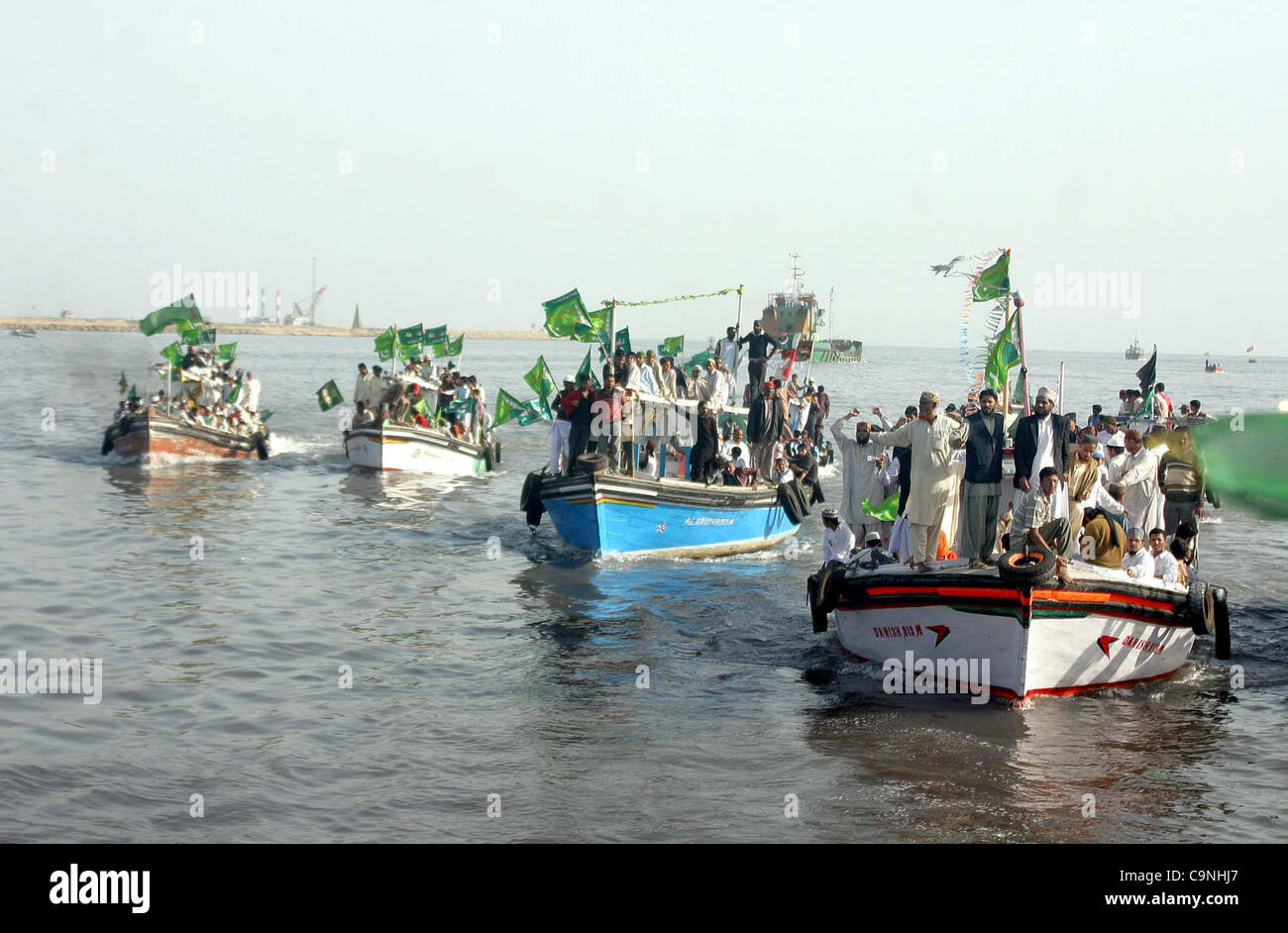 Supporters of Jamat-e-Ahle Sunnat ride on boats during boats rally from Manora to Kemari in the connection of Jashan-e-Eid Milad-un-Nabi (SAW) in Arabian Sea in Karachi on Wednesday, February 01, 2012. Stock Photo