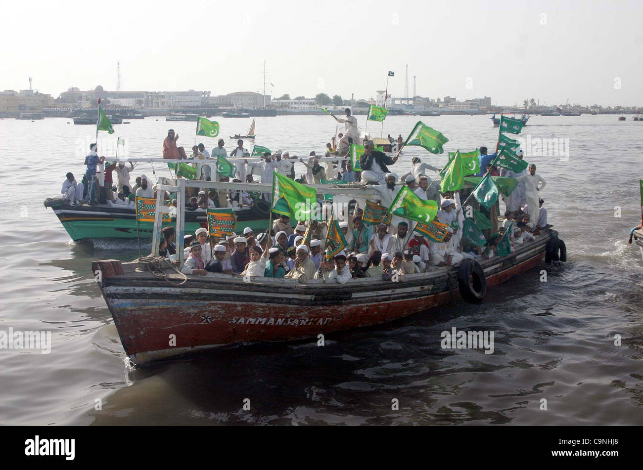 Supporters of Jamat-e-Ahle Sunnat ride on boats during boats rally from Manora to Kemari in the connection of Jashan-e-Eid Milad-un-Nabi (SAW) in Arabian Sea in Karachi on Wednesday, February 01, 2012. Stock Photo