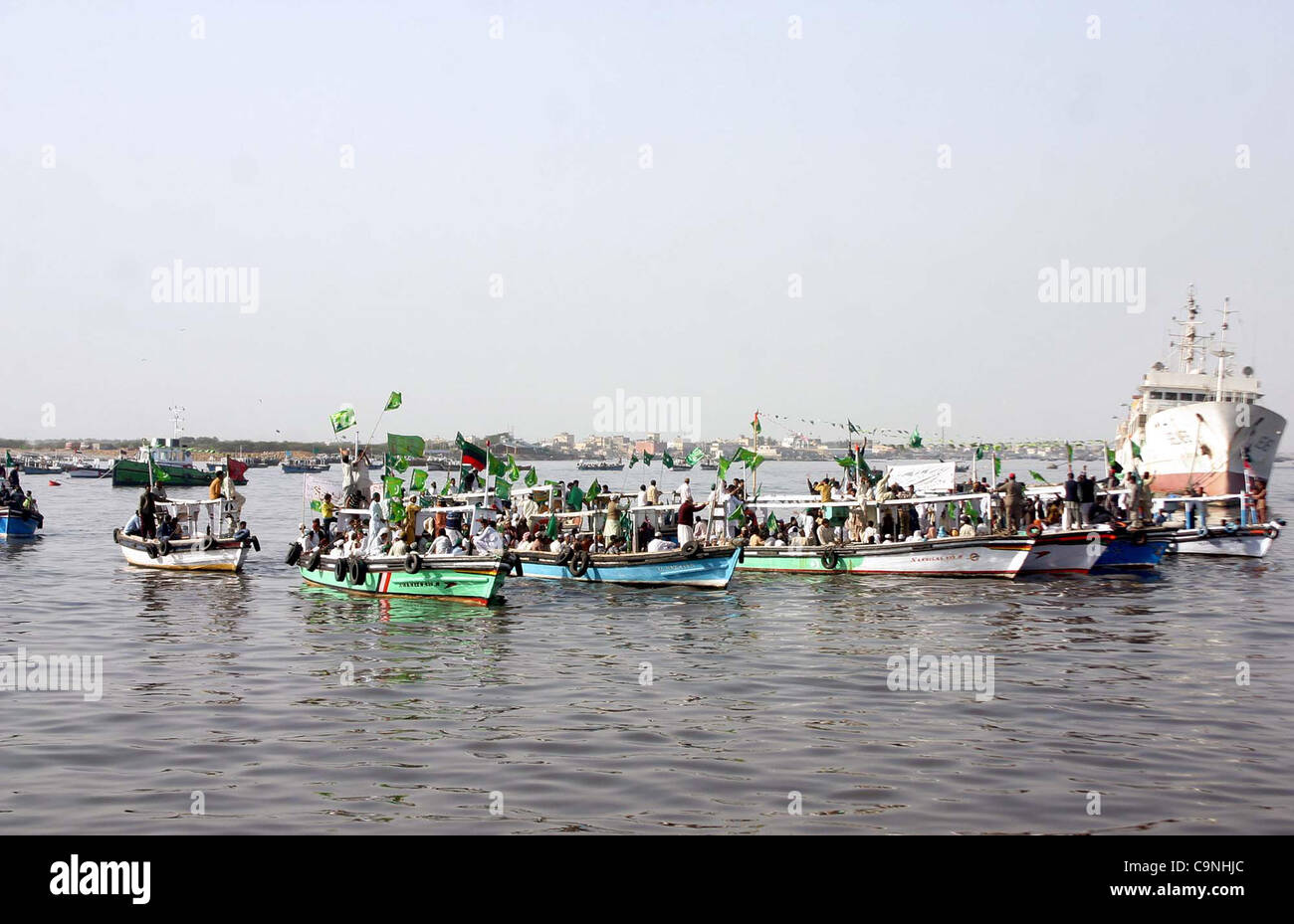 Supporters of Jamat-e-Ahle Sunnat ride on boats during boats rally from Manora to Kemari in the connection of Jashan-e-Eid Milad-un-Nabi (SAW) in Arabian Sea in Karachi on Wednesday, February 01, 2012. Stock Photo