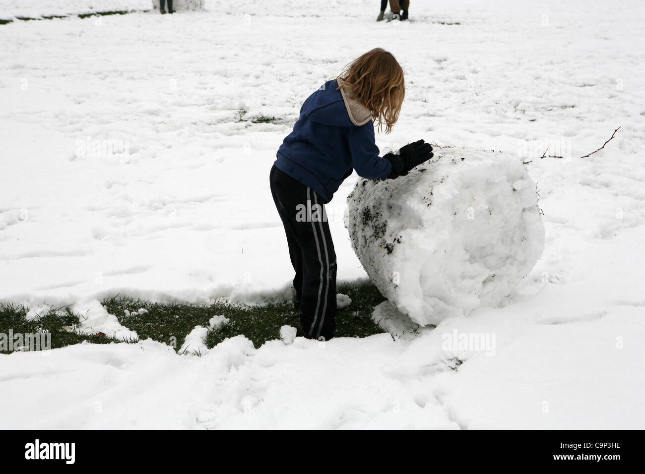 Child Making Snowballs A child is making a snow ball in Kennington Park, London on 5th ...