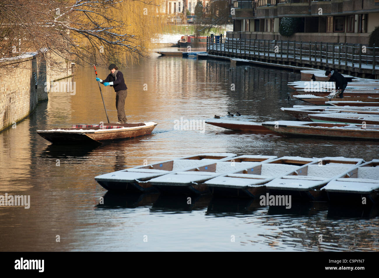 Cambridge, UK. 10th Feb, 2012. A punt is manoeuvred on the River Cam in Cambridge in snowy conditions on 10th February 2012. The tourist attraction continued despite the wintry weather. Stock Photo